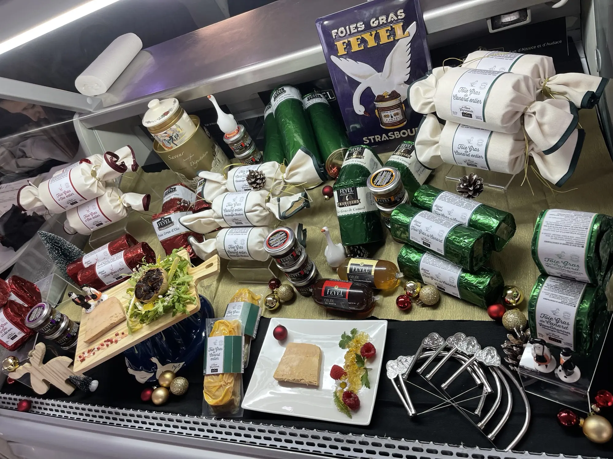 Présentation en vitrine de foies gras Feyel en ballotins, conserves, plats et décorations de fêtes