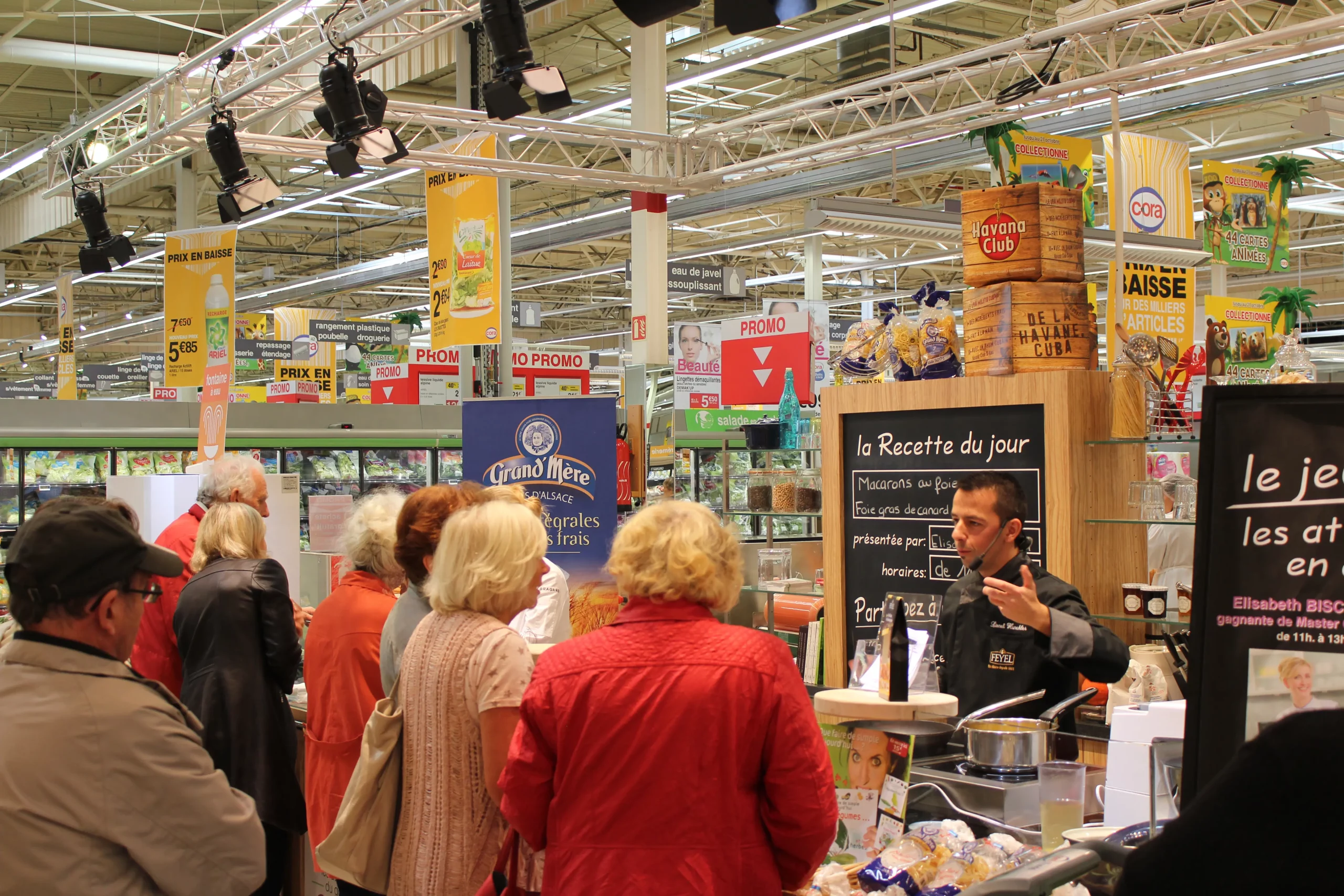Atelier de dégustation animé en magasin, avec chef cuisinier, recettes et public attentif